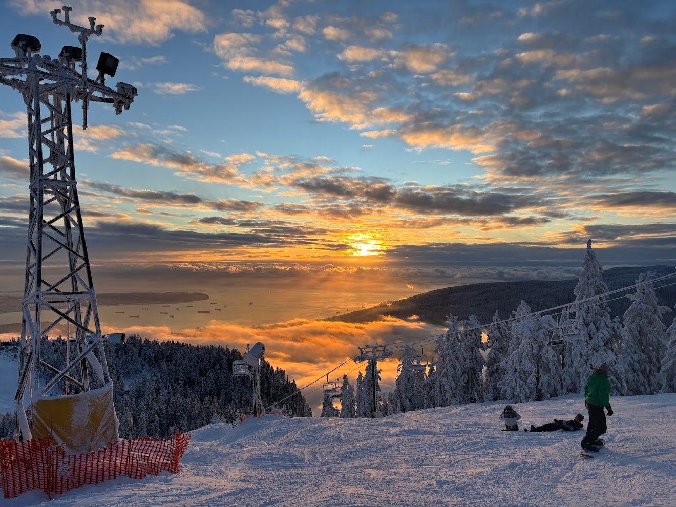 白天的松鸡山，白雪覆盖，因为刚下过初雪，雪况很粉。天空澄澈，云朵四散，太阳正在落山，但是还没到夕阳，金黄的阳光穿透云海，丁达尔效应形成若干光柱，打在海面上。